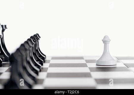 Focus sélectif d'échiquier avec pièces d'échecs noir et le pion blanc en face isolated on white Banque D'Images