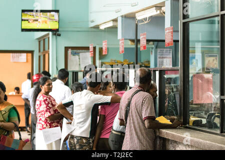 Galle, Sri Lanka - Février 18th, 2019 : Queue de personnes en attente au guichet de la poste centrale au centre-ville de Galle, au Sri Lanka. Banque D'Images