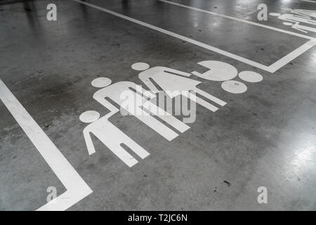 Parking avec icône de famille peint sur un sol en béton Banque D'Images