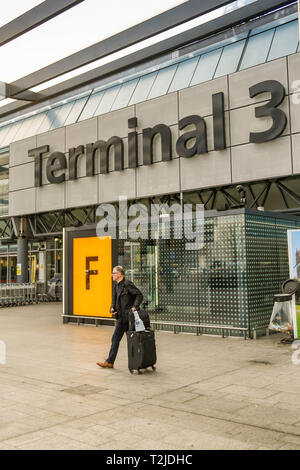 De l'aéroport Heathrow de Londres, ANGLETERRE - Février 2019 : Personne suitcase de quitter le Terminal 3 de l'aéroport Heathrow de Londres, après son arrivée au Royaume-Uni Banque D'Images