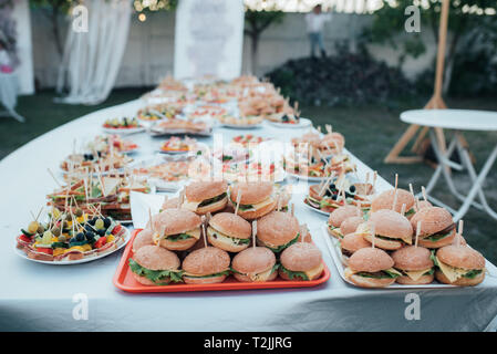 Buffet de mariage avec diverses collations et des hamburgers dans la nature. Banque D'Images