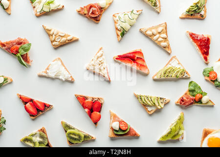 Vue de dessus de délicieux toasts avec fruits, légumes et cacahuètes isolated on white Banque D'Images