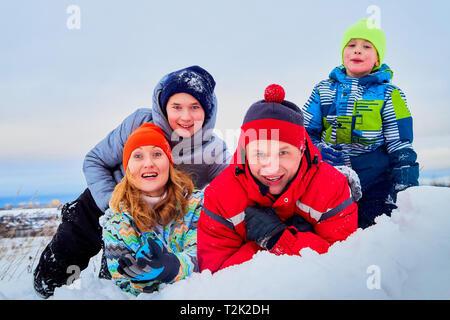 Portrait d'une famille de quatre personnes dans la neige. Papa, maman et ses deux fils dans une journée d'hiver Banque D'Images