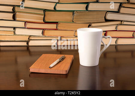Les vieux livres sur table en bois avec plateau et ordinateur portable ouvert Banque D'Images