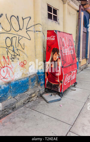 Un Coca Cola distributeur automatique avec un portrait peint sur le côté, sur un trottoir à Cochabamba, Bolivie. Banque D'Images