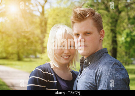 Young couple journée de printemps ensoleillée dans un parc - de vraies personnes avec sun flare lumière filtre de fuite Banque D'Images