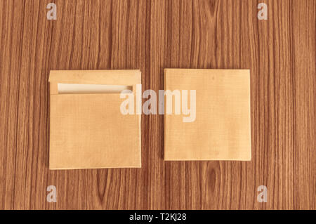 Ensemble de deux enveloppe brune avant et à l'arrière isolé sur fond de plancher de table en bois. Des cartes vierges. Immersive. Haut Haut angel afficher un objet Banque D'Images