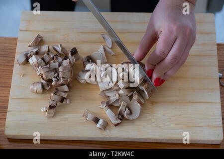 Champignons coupe femme sur planche de bois Banque D'Images
