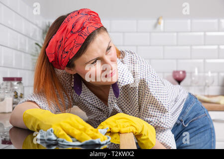 Jolie femme faire ses corvées maison à essuyer la cuisson ménagère. Banque D'Images