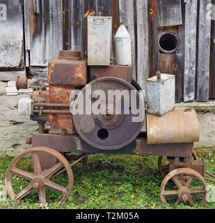 Rusty vintage petits tracteurs et machines retrol moteur diesel près de la grange en bois en milieu rural. L'équipement en métal est faite plus de cent ans Banque D'Images