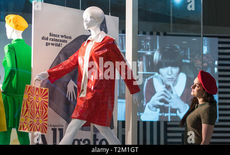 Une galerie assistant contrôle l'affichage des capes de pluie à partir de 1967 lors d'un aperçu de la nouvelle V&Une exposition de pièces de designer de mode Mary Quant au Victoria & Albert Museum, London. Banque D'Images