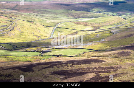 À partir de taches d'ombre intermittent nuages tombent sur de vastes terres agricoles dans le Peak District, en Angleterre. Banque D'Images