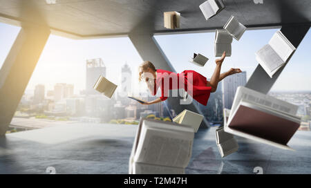 Relaxed woman fait léviter dans la salle pleine de voler des livres. Technique mixte Banque D'Images