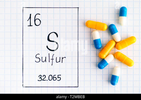 L'élément chimique de l'écriture manuscrite S Soufre avec certaines pilules. Close-up. Banque D'Images