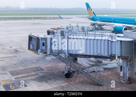 Pont d'embarquement ou de jet pont sur la préparation par l'équipage de service au sol pour les écarter ou arriver à l'aéroport international de Noi Bai à Hanoi, Vietnam. Banque D'Images