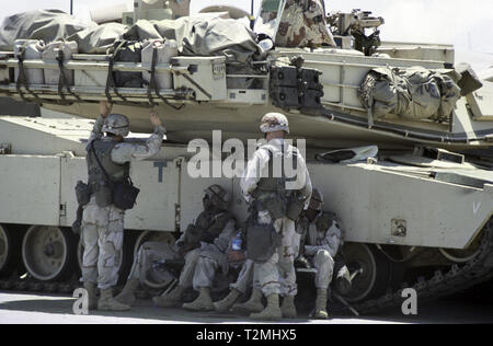 30 Octobre 1993 Des soldats de l'Armée américaine à l'abri de la chaleur féroce à l'ombre de leurs M1A1 Abrams tank de la 24e Division d'infanterie, 1e Bataillon du 64e régiment blindé. Ils viennent d'arriver dans le nouveau port de Mogadishu, Somalie. Banque D'Images