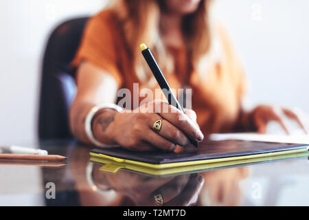 Close up de la part d'un illustrateur de faire un dessin à l'aide d'une feuille de travail. Cropped shot d'une femme artiste créateur travaille sur un dessin numérique pavé numérique. Banque D'Images