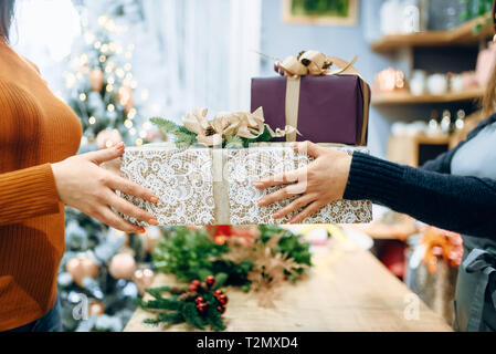 Vendeur service d'emballage cadeau de noël client donne à fort. L'acheteur a commandé un paquet de présents, d'emballage de fête Banque D'Images