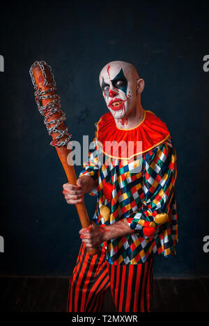 Crazy clown sanglant avec batte de baseball. Homme avec un miroir en costume halloween Banque D'Images