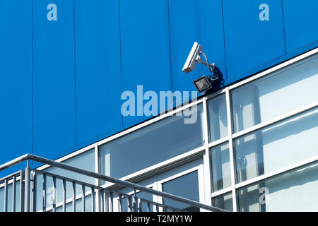 Concept de surveillance. Caméra de sécurité sur la façade de l'immeuble bleu Banque D'Images