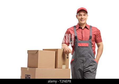 Delivery man s'appuyant sur une pile de boîtes chargé sur un camion de main isolé sur fond blanc Banque D'Images