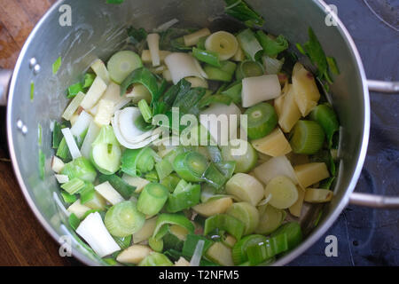 La cuisson des pommes de terre et les poireaux dans une casserole. Banque D'Images