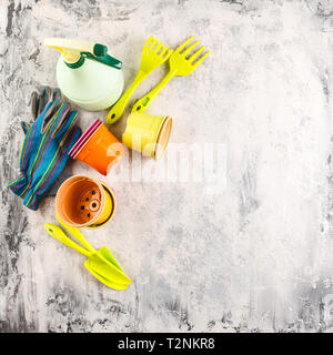 Pots de fleurs de printemps et de jacinthes narcisses avec outils de jardinage sur fond clair Banque D'Images