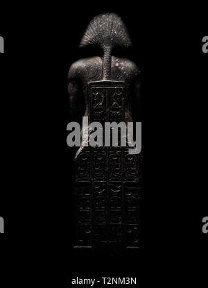 La figure de l'allusif, pharaon isolé sur fond noir vu de derrière avec des gravures. Banque D'Images