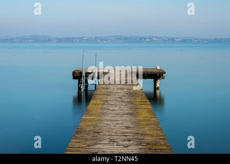 Jetée en bois sur le lac de Garde près de la ville de Sirmione, Italie Banque D'Images