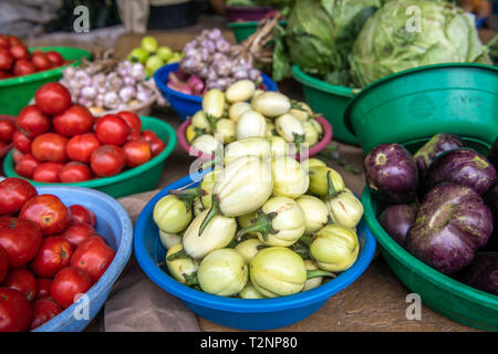 Bols en plastique plein d'aubergines et tomates au marché en plein air, le Rwanda Farmers Market, au Rwanda Banque D'Images