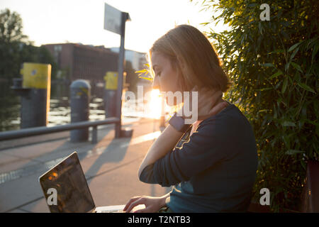 Young woman using laptop café à l'extérieur, Berlin, Allemagne Banque D'Images