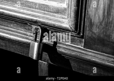 Ancienne serrure sur une porte en bois avec rusty cadenas fermé, vintage photo en noir et blanc Banque D'Images