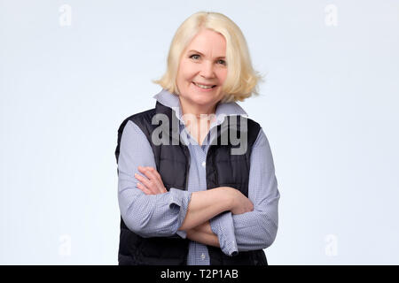 Smiling senior femme aux cheveux blonds à la confiance à l'appareil photo. L'émotion du visage humain positif Banque D'Images