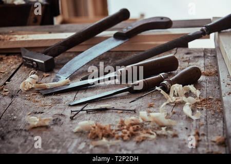 Portrait d'un atelier de travail du bois rustique avec de vieux outils à main vintage y compris les ciseaux, marteau, scie et rasp ou fichier sur l'établi Banque D'Images