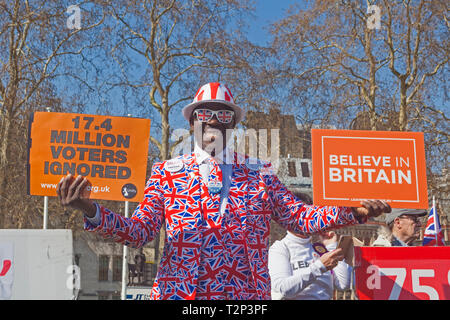 Londres, Westminster. Un activiste habillé de couleurs vives en place du Parlement le 29 mars 2019, l'original "Brexit laissant jour.' Banque D'Images