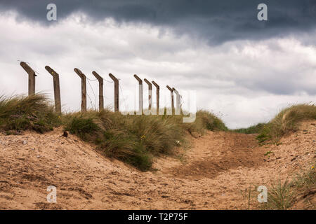 Les dunes de sable et les poteaux de clôture en angle avec un moody sky à une plage à Hartlepool en Angleterre du Nord-Est Banque D'Images