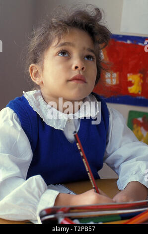 Petite fille contemplative dans la classe de l'école Banque D'Images