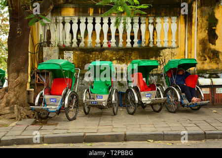 Hoi An, Vietnam - 20 décembre 2017. Un conducteur a une sieste dans son cyclo lors de l'attente pour les clients sur une rue dans le quartier historique de l'UNESCO énumérés Viet Banque D'Images