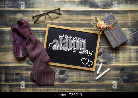 Happy Father's Day concept. Mise à plat de l'image boîte cadeau, cravate, lunettes et tableau avec Happy Father's Day text. Banque D'Images