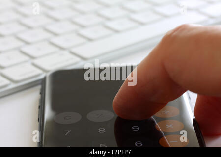 Smartphone avec doigts de toucher l'écran et clavier en arrière-plan. Focus sélectif et extreme close up et contraste dur estompe pour copier bref Banque D'Images