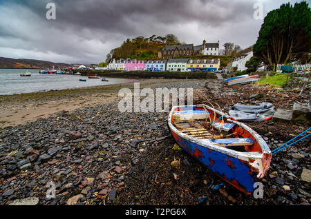 Un bleu bateau à marée basse avec des bâtiments colorés en arrière-plan sur le port de Portree, Isle of Skye Banque D'Images