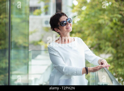 Closeup portrait of smiling head shot charmant joyeux mature femme regardant vers le haut la rêverie nice future thinking vert extérieur isolé backgrou Banque D'Images