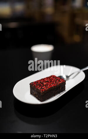 Avec Brownie avec rouge vif framboise Épices sèches dans un bar café Banque D'Images