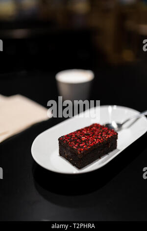 Avec Brownie avec rouge vif framboise Épices sèches dans un bar café Banque D'Images