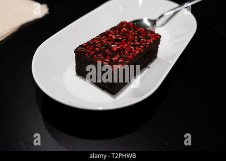 Avec Brownie avec rouge vif framboise Épices sèches dans un bar café Banque D'Images