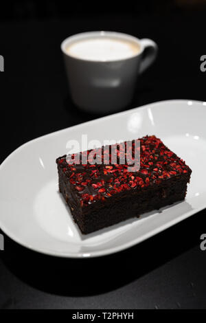 Avec Brownie avec rouge vif framboise Épices sèches dans un bar café Banque D'Images