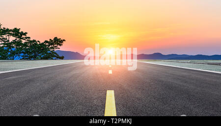 Tout droit sur la route asphaltée et belle montagne nature paysage au coucher du soleil Banque D'Images