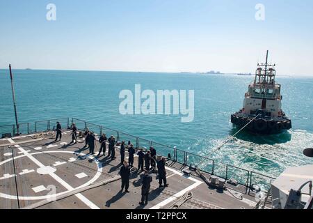 Les marins américains affectés à missiles de l'USS Stockdale (DDG 106), fake une ligne sur le pont d'envol du navire alors qu'au départ de Manama, Bahreïn, le 12 mars 2019. L'Stockdale est déployé sur le 5e flotte américaine zone d'opérations à l'appui des opérations navales pour assurer la stabilité et la sécurité maritime dans la région Centrale, reliant la Méditerranée et le Pacifique à travers l'ouest de l'Océan indien et trois points d'étranglement stratégiques. (U.S. Photo par marine Spécialiste de la communication de masse 2e classe Abigayle Lutz) Banque D'Images