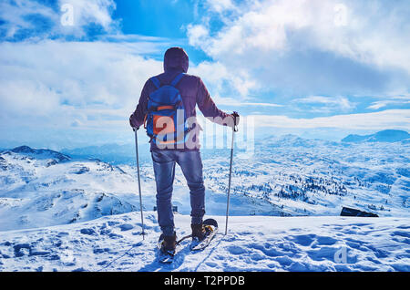 Le raquetteur se dresse sur le bord de la montagne enneigée Krippenstein et regarder le paysage de massif du Dachstein et pittoresque au-dessus, Salzkammerg cloudscape Banque D'Images