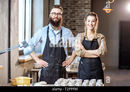 Portrait d'un homme créatif et la femme comme des travailleurs ou des propriétaires d'entreprise à la boutique de la poterie Banque D'Images